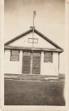 School house with double door possibly ending in the word Creek, flying Union Jack Flag, teacher Ingeborg Bergquist later Mrs Ingeborg Peterson